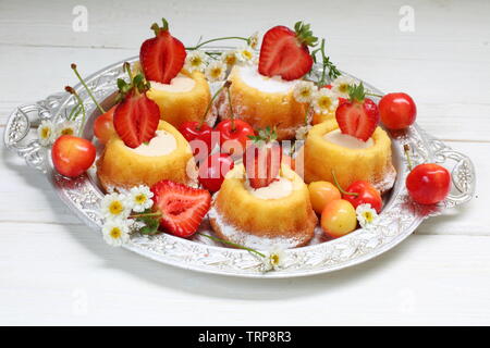 Cupcakes mit Erdbeeren auf einem weißen Holz- Hintergrund Stockfoto