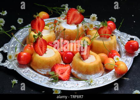 Cupcakes mit Berry Cream auf schwarzem Hintergrund Stockfoto