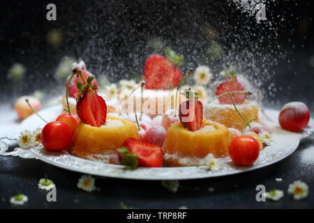 Cupcakes mit Berry Cream auf schwarzem Hintergrund Stockfoto