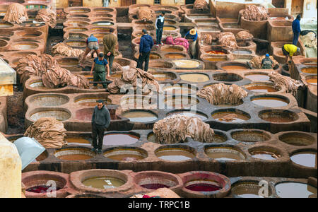 Schiffe mit uv Flüssigkeiten und Arbeiter produzieren und Färben von Leder in traditioneller Weise an der Chouara Gerberei. Fez, Marokko. Stockfoto