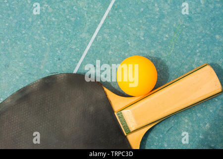 Ping pong Paddles und Ball auf Retro blau Holz- Hintergrund. Schläger von Zeit ruiniert Stockfoto