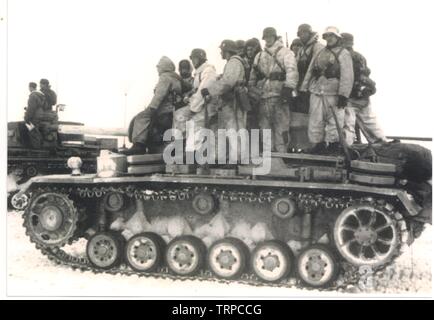 Deutsche Soldaten/Waffen-SS im Winter weißen Parkas Fahrt auf einem Panzer Panzer III während der Schlacht um Charkow 1943 an der russischen Front Stockfoto
