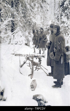 Deutsche Soldaten standind den Schnee hinter einem schweren Maschinengewehr MG 34 an der russischen Front Winter 1841 Stockfoto