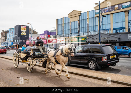 Touristen genießen Sie ein Pferd und Kutsche fahren entlang der Goldenen Meile, d. h. direkt am Meer, in der Küstenstadt Great Yarmouth, Norfolk Stockfoto