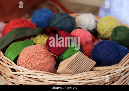 Stricken und Handarbeit, Weidenkorb mit bunten Knäuel Garn Stockfoto