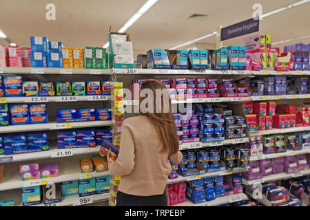 Eine Frau stellt bei Sanitärprodukten in einem Tesco Supermarkt in West London, am 9. Juni 2019. Stockfoto