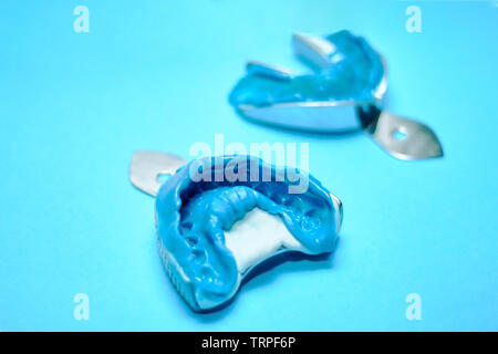Zwei zahnmedizinische Eindrücke auf einem blauen Hintergrund mit kopieren. Zahnmedizinische Formen vom oberen und unteren Kiefer der Silikon Material. Der Abdruck der Zahn Stockfoto