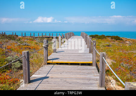 Die hölzerne Treppe an der felsigen Küste an einem sonnigen Tag. Polvoeira den Strand. Pataias, Portugal, Europa Stockfoto