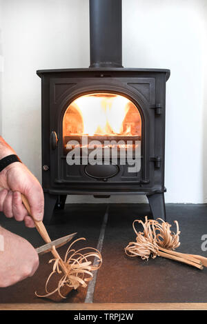 Person Carving Feather Sticks für Nähre in einem Holzofen/Multi-Fuel Herd, Großbritannien Stockfoto