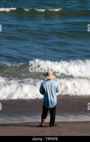 Nha Trang Vietnam, Silhouette der Mann Angeln vom Strand am späten Nachmittag Stockfoto