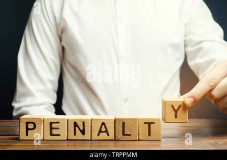 Ein Mann legt einen hölzernen Blöcke mit dem Wort Strafe. Feine als Strafe für ein Verbrechen und Vergehen. Verstöße gegen Verkehrsregeln. Legalisiert/finanzielle Puni Stockfoto