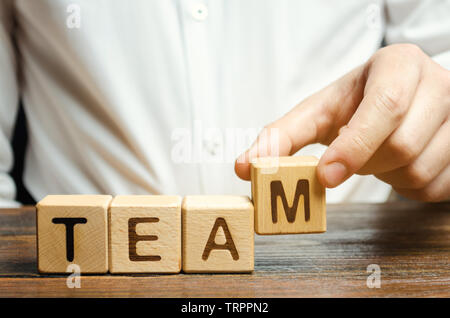 Unternehmer hält Holzblöcke mit dem Wort Team. Team Management Konzept. Teamarbeit. Die Einstellung. Einstellung von Personal. Arbeiten in Zusammenarbeit. Führung Skil Stockfoto