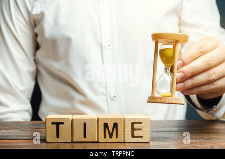 Ein Mann legt Holzblöcke mit dem Wort Zeit. Konzept der Zeit Verwaltung und ordnungsgemäße Verteilung. Planung Wirtschaft und Arbeit. Business Jugend. Analyse Stockfoto