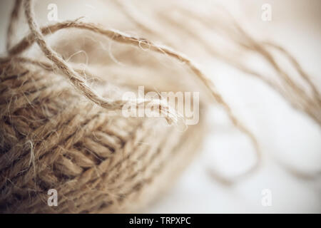 Flauschige der Hanf Faden wird in eine Kugel gesammelt. Die Spitze der Thread aus der Kugel kleben und Fluffed und durch Licht beleuchtet. Stockfoto