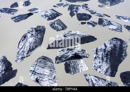 Luftaufnahme von schwimmenden Eisberge vom Gletscher schmelzen in den See Wasser als Folge der globalen Erwärmung, die von einer Drohne oben gesehen. Svinafellsjokull See, Stockfoto