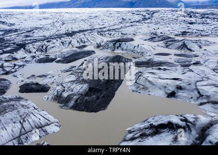 Luftaufnahme von schwimmenden Eisberge vom Gletscher schmelzen in den See Wasser als Folge der globalen Erwärmung, die von einer Drohne oben gesehen. Svinafellsjokull See, Stockfoto
