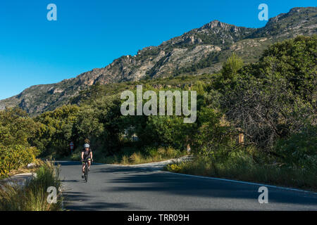 Wicklung auf die Gebäude in der Skyline ridge, eine weibliche Radfahrer Zyklen bis die schöne Ziege Pfad Road (A-4050), Sierra Nevada, Spanien Stockfoto