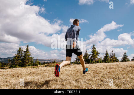 Zurück männliche Läufer laufen querfeldein Außenpool im Sommer Stockfoto