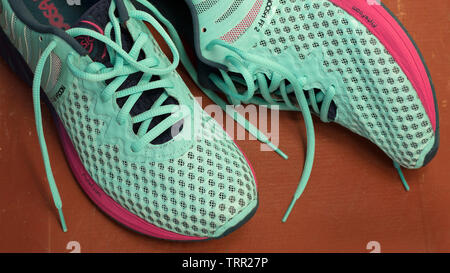 7/8 Schuß von trendigen Asics NOOSA FF 2 Schuhe in Marineblau, Hellblau und Lila Farben für die Ausführung auf terracotta Hintergrund. Moskau - Juni 2019. Fem Stockfoto