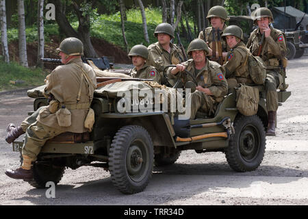 Sieben reenactors verkleidet als Soldaten der US-Army 82nd Airborne "All American" Abteilung auf einen Jeep. Stockfoto