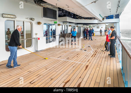 Passagiere Shuffleboard spielen auf dem Deck der TUI Kreuzfahrtschiff Marella Explorer, Nordsee, Europa Stockfoto