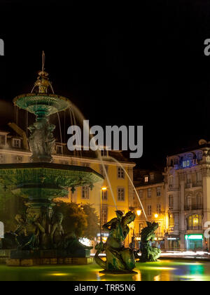 Lissabon, Portugal. Brunnen im Dom Pedro IV aka Rossio Square bei Nacht mit Meerjungfrauen und mythologischen Kreaturen. 19. jahrhundert Val d'Osne Gießerei-Arbeit. Stockfoto