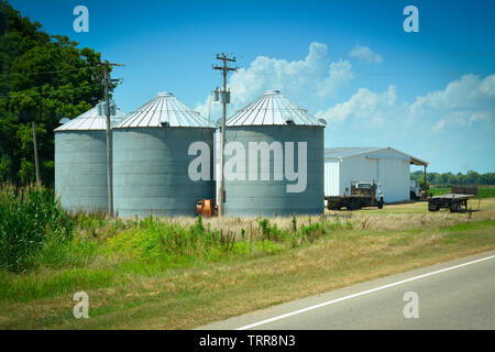 Industrielle noch künstlerische zylindrische Metall Silos auf Ackerland in ländlichen Nordwesten von Mississippi, USA Stockfoto