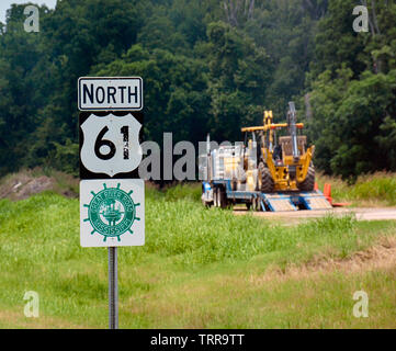 Eine Planierraupe auf einem Traktoranhänger rig ist neben einem Hinweisschild für North 61 im Nordwesten von Mississippi geparkt, entlang der historischen Großen Stockfoto