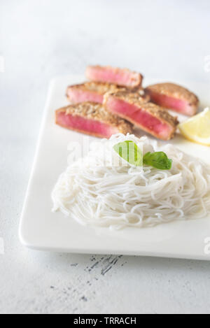 Reis Nudeln mit gebratenen Thunfisch mit Sesam auf die weiße Platte Stockfoto