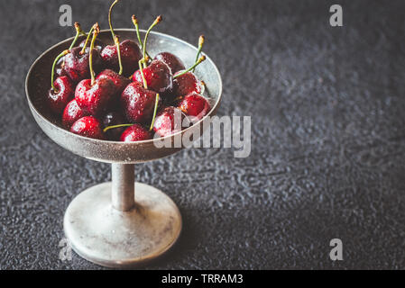 Frische Kirschen in Vintage silver Vase auf dem dunklen Hintergrund Stockfoto