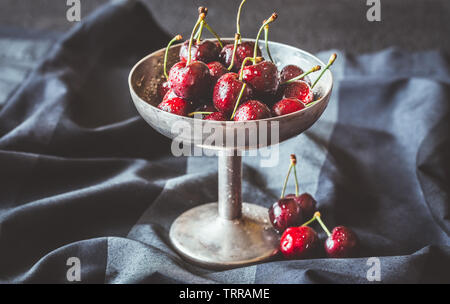 Frische Kirschen in Vintage silver Vase auf dem dunklen Hintergrund Stockfoto