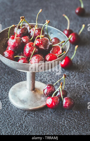 Frische Kirschen in Vintage silver Vase auf dem dunklen Hintergrund Stockfoto