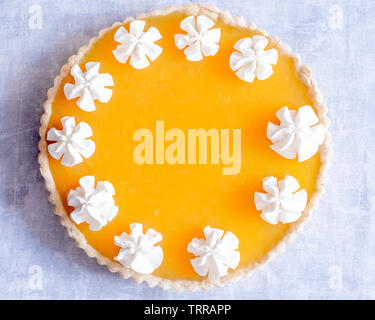 Ansicht von oben Flach Orange Jelly Passionfruit Torte mit Schlagsahne geleitet auf den Umriss über einen hellgrauen Hintergrund Stockfoto
