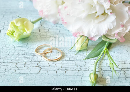 Blumenstrauß mit zwei goldene Ringe an den Holz- Hintergrund Stockfoto