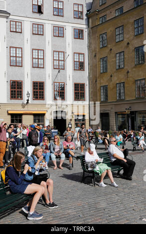 Stockholm, Schweden - 10. Juni, 2019; Leute sitzen auf Bänken am Platz Stortorget in der Altstadt. Stockfoto