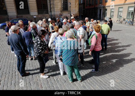 Stockholm, Schweden - 10. Juni 2019: Hohe Betrachtungswinkel und einer Gruppe von Touristen, die einen Kreis am Platz Stortorget in der Altstadt gebildet hat. Stockfoto