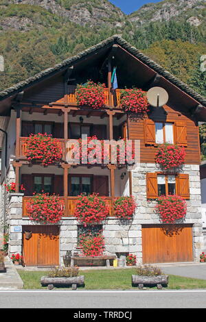 Italien Piemont Seen Lago d'Giulio italienischen Alpen Valsesia Tal Piode traditionellen Steinhäuser mit roten Blumen Geranien Architektur Garten Stockfoto