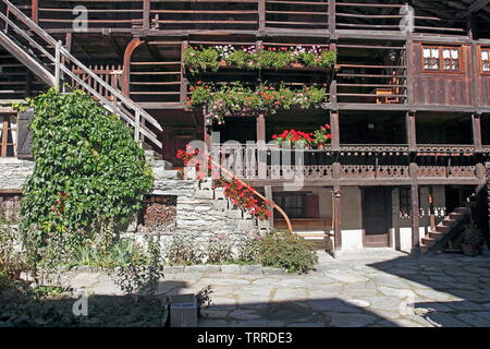 Italien Piemont Seen Lago d'Giulio italienischen Alpen Alagna Valsesia Tal traditionelle Walser Holz Gebäude mit roten Blumen Geranien Architektur Stockfoto