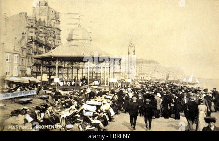 Einem frühen zwanzigsten Jahrhundert Postkarte von Hastings, East Sussex, England, ein Kiosk und eine Masse als Publikum. Stockfoto