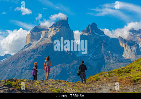 Eine Gruppe von drei Touristen auf der Suche nach den Anden Gipfel der Cuernos Del Paine im chilenischen Patagonien. Unscharfer Vordergrund, scharfen Hintergrund. Stockfoto