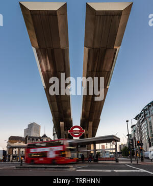 London, England, UK - 28. Mai 2019: Busse fahren unter der markanten auskragenden Dach von Vauxhall Busbahnhof im Süden Londons in der Abenddämmerung. Stockfoto