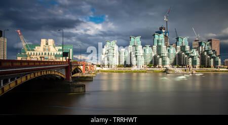 London, England, UK - 28. Mai 2019: Die Themse fließt unter der Vauxhall Bridge, mit dem markanten St George's Wharf Apartment Gebäude hinter. Stockfoto