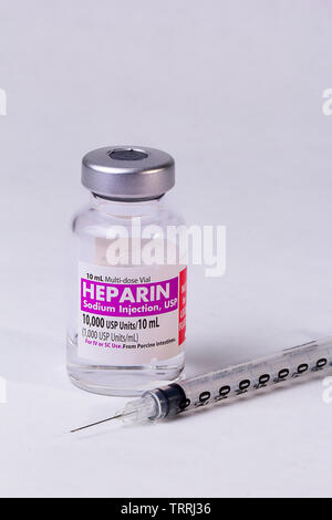 Eine Flasche für das gerinnungshemmende Medikament Heparin Natrium mit einer Spritze auf weißem Hintergrund Stockfoto