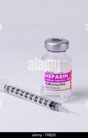 Eine Flasche für das gerinnungshemmende Medikament Heparin Natrium mit einer Spritze auf weißem Hintergrund Stockfoto