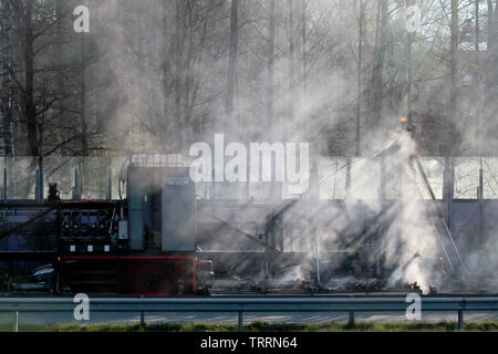 Hameenlinna Finnland 05/04/2016 Die Autobahn ist unter ebnet mit Asphalt. Die asphaltierung Maschinen und Lastwagen sind langsam nach vorn bewegen. Die Luft ist voller Stockfoto