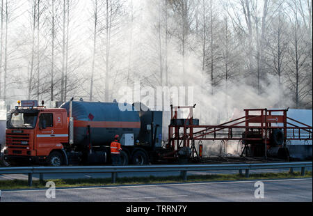 Hameenlinna Finnland 05/04/2016 Die Autobahn ist unter ebnet mit Asphalt. Die asphaltierung Maschinen und Lastwagen sind langsam nach vorn bewegen. Die Luft ist voller Stockfoto