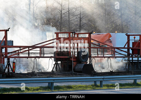 Hameenlinna Finnland 05/04/2016 Die Autobahn ist unter ebnet mit Asphalt. Die asphaltierung Maschinen und Lastwagen sind langsam nach vorn bewegen. Die Luft ist voller Stockfoto