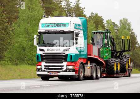 Raasepori, Finnland. 24. Mai 2019. Bunte Scania R 560 Auflieger der kuljetusliike ich Huohvanainen Oy neuen John Deere Forstmaschinen auf Straße Hols Stockfoto