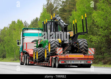 Raasepori, Finnland. 24. Mai 2019. Scania Auflieger der kuljetusliike ich Huohvanainen Oy neuen John Deere Forstmaschinen auf Straße schleppt, Ansicht von hinten. Stockfoto