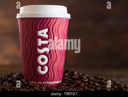 LONDON, UK - Juni 05, 2019: Costa Coffee im Pappbecher zum Mitnehmen mit Kaffeebohnen auf Holz. Stockfoto